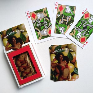 May include: A deck of playing cards with a custom design featuring a woman in a swimsuit and pears. The cards are labeled "Thots & Pears".