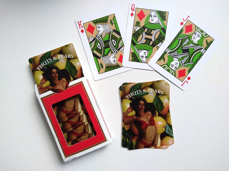 May include: A deck of playing cards with a custom design featuring a woman in a swimsuit and pears. The cards are labeled "Thots & Pears".