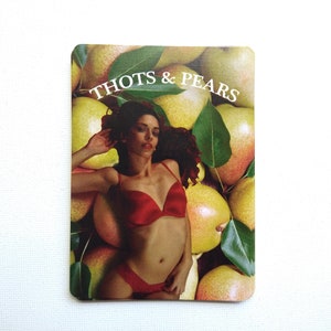May include: A woman in a red bikini lays on a bed of yellow pears with green leaves. The text "THOTS & PEARS" is printed at the top of the image.