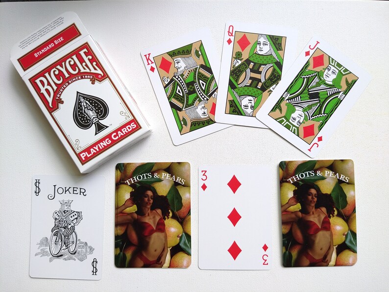 May include: A set of playing cards featuring a standard deck of Bicycle playing cards, a joker card, and four cards from a deck of Thoth & Pears playing cards. The Thoth & Pears cards feature a woman in a red bikini surrounded by pears.