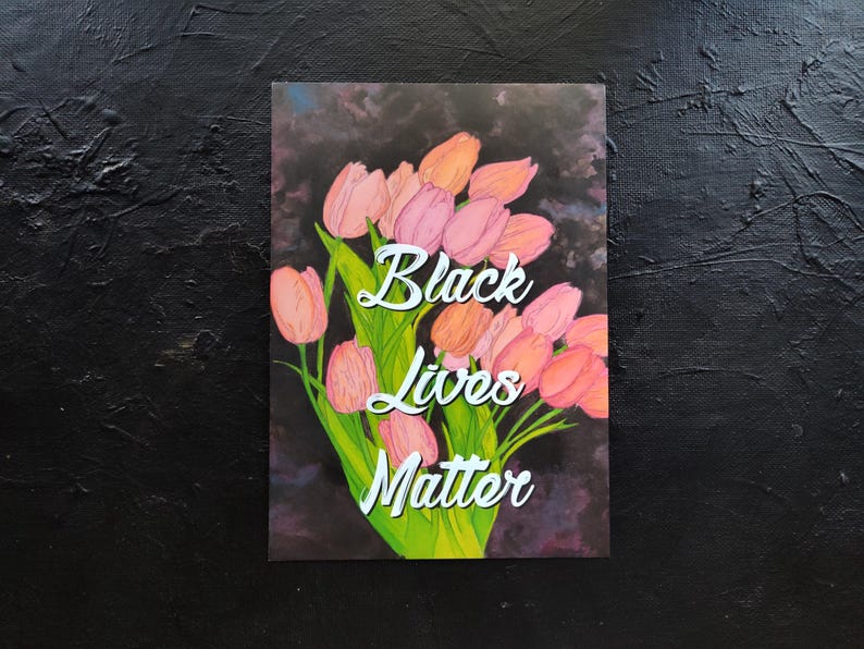 May include: An art print showing a bouquet of pink and orange tulips with green stems and leaves. The words "Black Lives Matter" are written in white script across the image, set against a dark background.