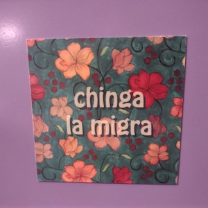 Puede incluir: Una impresi&oacute;n floral colorida con el texto "chinga la migra" en letras blancas.