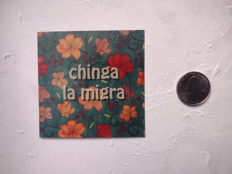 Puede incluir: Una pegatina con un dise&ntilde;o floral en tonos rojos, naranjas y verdes. La pegatina tiene el texto "chinga la migra" en letras blancas.