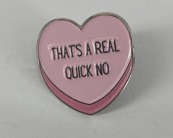 May include: Pink heart-shaped pin with a silver border. The pin says "That's a real quick no."