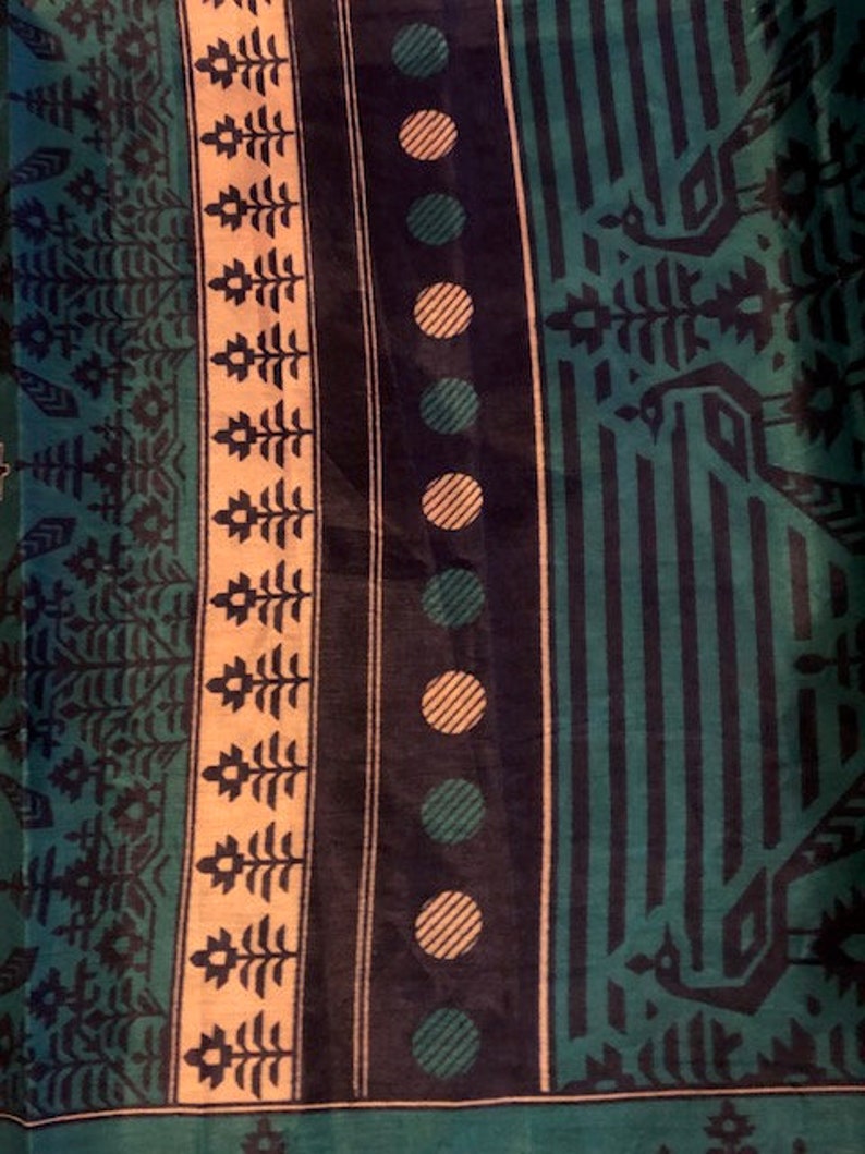 May include: A fabric with a repeating pattern of green, black, and white. The pattern includes geometric shapes, circles, and stylized trees.