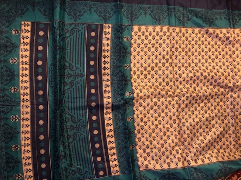 May include: A teal and black patterned fabric with a cream colored background. The fabric has a repeating geometric design.