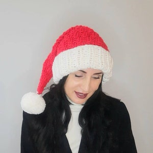 A warm winter hat. Santa hat for women. Long knitted stocking. Stocking cap with pompon.