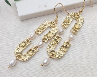 Pendientes largos de perlas de agua dulce chapados en oro, estilo bohemio, con un arco llamativo.