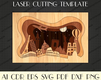 May include: Laser cutting template featuring a layered design of famous landmarks from around the world, including the Eiffel Tower, the Colosseum, and the Statue of Liberty. The template is made of wood and has a brown color.