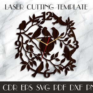 May include: A laser cut clock design featuring a brown wooden clock face with black branches and birds. The clock face has Roman numerals and a gold and red clock hand. The design is suitable for laser cutting.