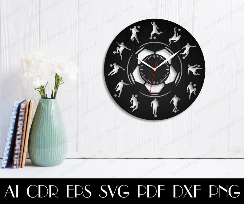 May include: Black and white clock with a soccer ball design. The clock face features a soccer ball with a clock face inside. The clock hands are red. The clock is surrounded by 12 soccer players in various poses.