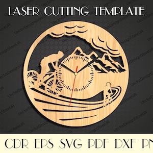 Puede incluir: Un diseño de reloj de madera cortado con láser que presenta una escena de montaña con un ciclista bajando una colina. La esfera del reloj está en el centro del diseño con una aguja de hora roja y una aguja de minuto negra.
