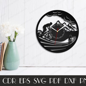 May include: Black and white silhouette of a mountain biker riding downhill with a clock face in the background. The clock face has a red hour hand and a black minute hand. The design is suitable for a wall clock.