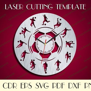 May include: A silver clock face with a soccer ball design. The clock face has 12 soccer players in various poses around the clock face. The clock face is surrounded by a silver ring with the text "LASER CUTTING TEMPLATE" at the top.