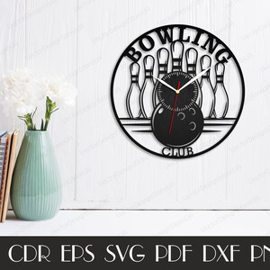 May include: Black laser-cut wall clock with a bowling theme. The clock features bowling pins, a bowling ball, and the words "BOWLING CLUB." The clock hands are black with a red second hand. The clock is mounted on a white wall.
