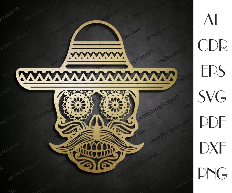 May include: A gold-colored, decorative, laser-cut design of a skull wearing a sombrero. The skull has intricate details, including a mustache, eyes, and teeth. The sombrero has a wide brim and a decorative pattern.