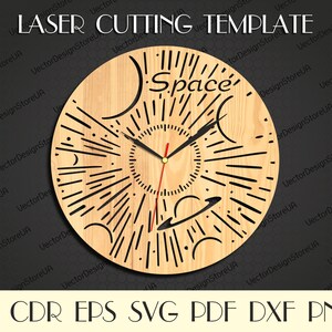 Puede incluir: Una esfera de reloj de madera cortada con láser con temática espacial. La esfera es redonda y tiene una veta de madera marrón claro. La esfera tiene un contorno negro y presenta un sol con rayos, planetas y estrellas. La esfera del reloj también tiene la palabra "Space" escrita en letras negras.