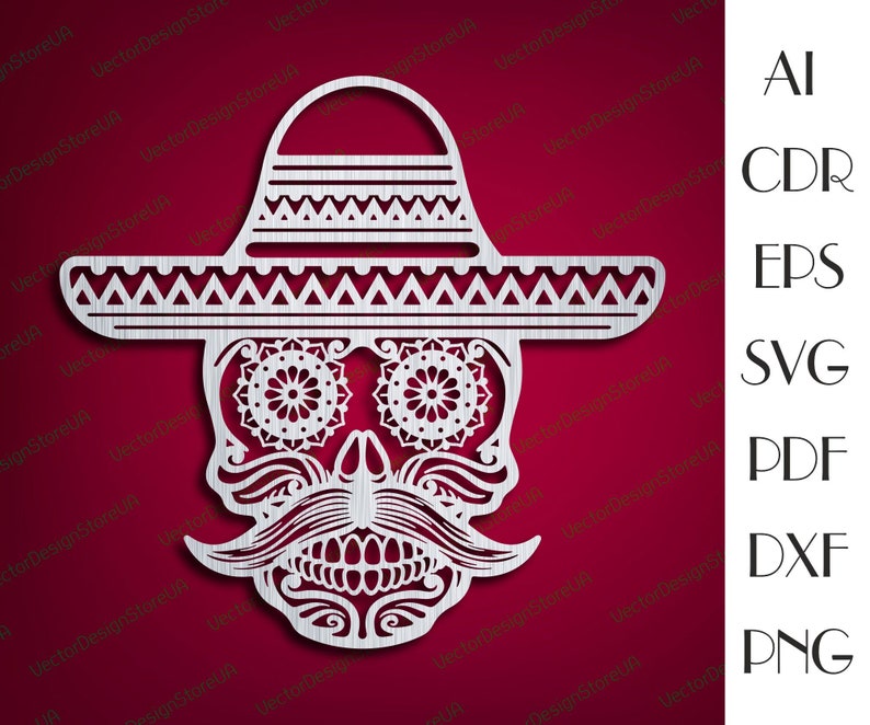 May include: A white, detailed, paper cut-out design of a skull wearing a sombrero. The skull has a mustache and a floral design around the eyes.