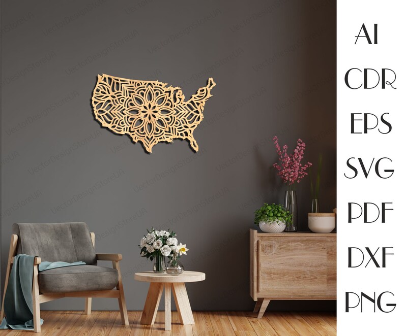 May include: A wooden wall decor in the shape of the United States with a mandala design. The decor is hanging on a gray wall above a wooden table and a brown armchair.