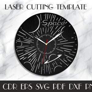 May include: A black clock face with a white and silver space-themed design. The clock face has a sun, planets, and stars. The text "Space" is written on the clock face.