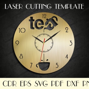 May include: A gold-colored clock face with black numbers and hands. The clock face has a cutout design of a teacup and teapot with the word "tea" written above it.