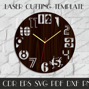 May include: A laser-cut wooden clock with a dark brown face and white numerals. The clock hands are yellow and red. The words "LASER CUTTING TEMPLATE" are at the top. The bottom of the image has file type abbreviations.