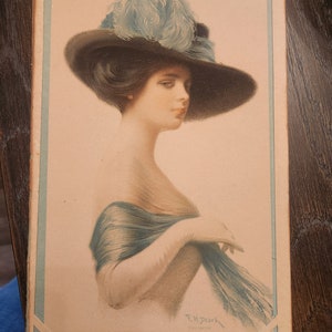 May include: A vintage illustration of a woman wearing a large, black hat with a blue feather trim. She is wearing a blue scarf and has a soft, delicate expression.