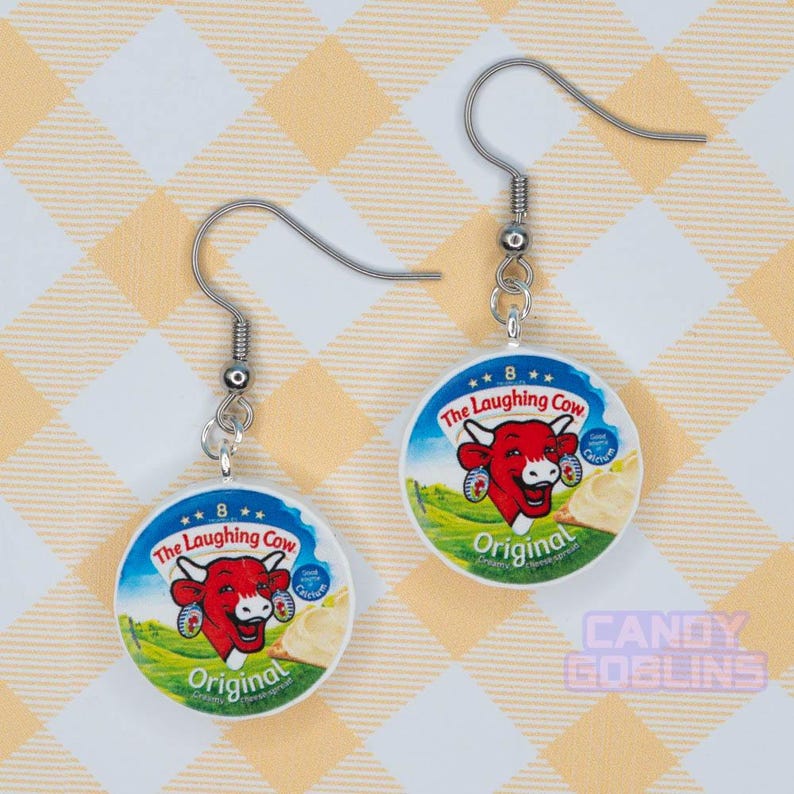 A pair of laughing cow earrings, featuring the laughing cow herself