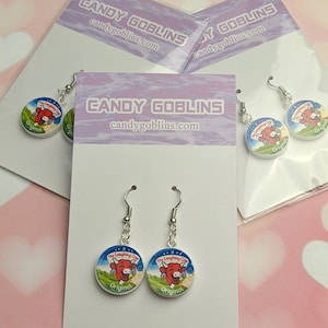 Three packets of Candy Goblins Laughing Cow earrings are packaged up and on display