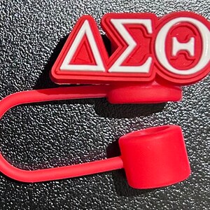 May include: Red silicone bottle stopper with a white and red Delta Sigma Theta sorority logo.