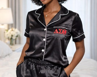 Pijama de satén negro con letras griegas rojas