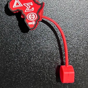 May include: Red silicone keychain shaped like the continent of Africa with the letters "&Delta;&Sigma;&Theta;" and the year "1913" printed on it.