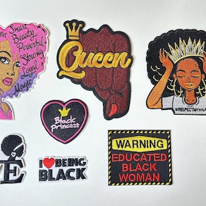 May include: Collection of embroidered patches with empowering messages and images. Includes a patch with a woman's face and the words "Queen, Smart, Beauty, Powerful, Strong, Loyal, Magic". Other patches say "Queen", "Black Princess", "Love", "I love being Black", and "Warning: Educated Black Woman".