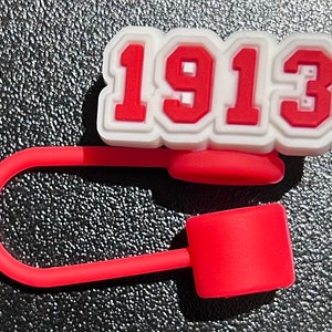 May include: Red and white silicone bottle stopper with the number 1913 printed on it.