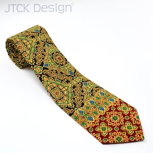 May include: A black, gold, green, and red patterned tie with a geometric design. The tie is rolled up at the top and the pattern is intricate.
