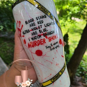 May include: White tumbler with a black and yellow crime scene tape design. The tumbler has red blood splatter and the text "Blood stains are red, ultra violet lights are blue. I watch enough murder shows. They'll never find you!"