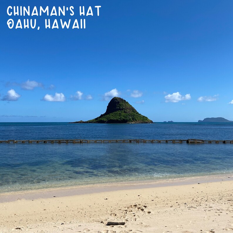 May include: A view of Chinaman's Hat, a small island off the coast of Oahu, Hawaii. The island is a popular tourist destination and is known for its unique shape, which resembles a hat.