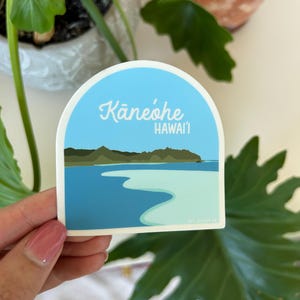 May include: A blue and white sticker with an illustration of a beach and the text "Kaneohe, Hawaii".
