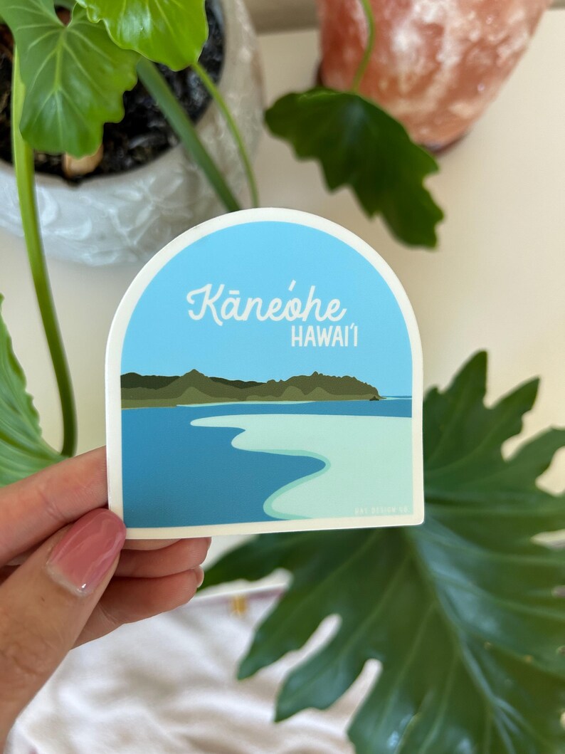 May include: A blue and white sticker with an illustration of a beach and the text "Kaneohe, Hawaii".