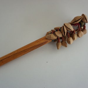 Un bâton de graines de maraca fabriqué avec des coquilles de noix - Artisanat