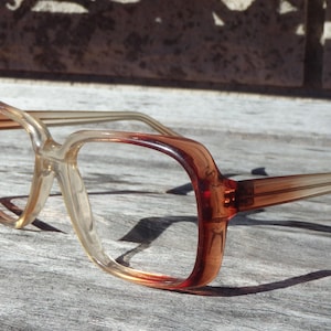 May include: A pair of brown and clear plastic eyeglasses with a square frame.