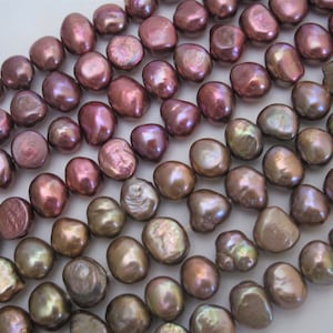 May include: A strand of iridescent, mauve-colored freshwater pearls. The pearls are irregularly shaped and have a slightly oval form.