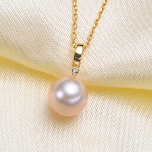Peut inclure: Un collier délicat en chaîne dorée avec un pendentif en perle rose unique et grand et un petit accent diamant.