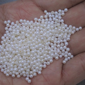 May include: A large pile of white pearl beads, perfect for crafting jewelry or adding a touch of elegance to any project.