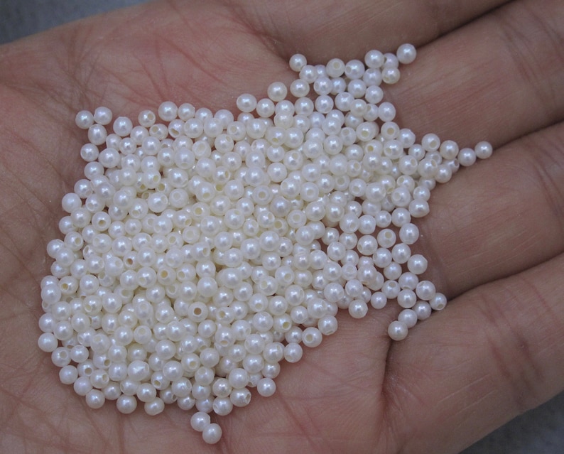 May include: A large pile of white pearl beads, perfect for crafting jewelry or adding a touch of elegance to any project.
