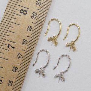 May include: Two pairs of earring hooks with a butterfly design. The hooks are made of metal and are available in gold and silver.