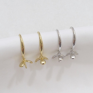 May include: Two pairs of earrings with a flower design. One pair is gold and the other is silver.