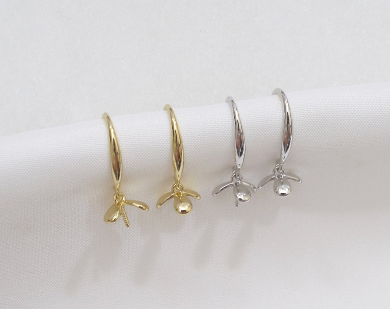 May include: Two pairs of earrings with a flower design. One pair is gold and the other is silver.