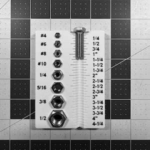 May include: A white ruler with measurements in inches and a selection of nuts and bolts. The ruler has measurements from 1/4" to 4-1/4". The nuts and bolts are arranged by size, with the largest at the bottom.