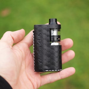 May include: Black leather vape case with white stitching and the text "Custom Leather Cases" embossed on the side.